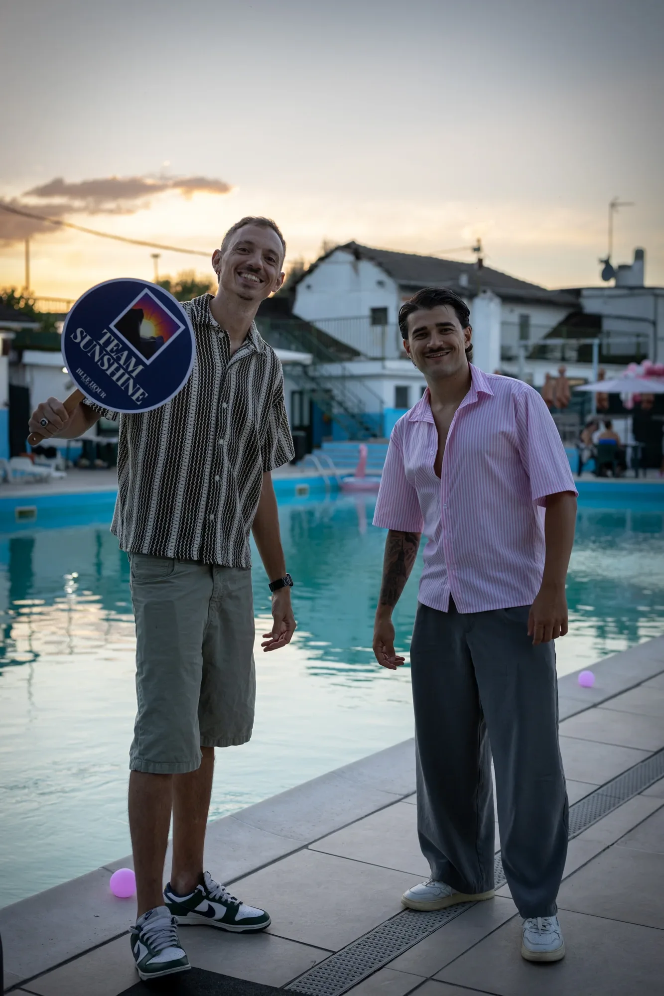 Yuri Daniele Di Stefano Gaudio ed Edoardo Monaco, co-fondatori del Blue Hour Deaf Club, sorridono a bordo piscina al tramonto